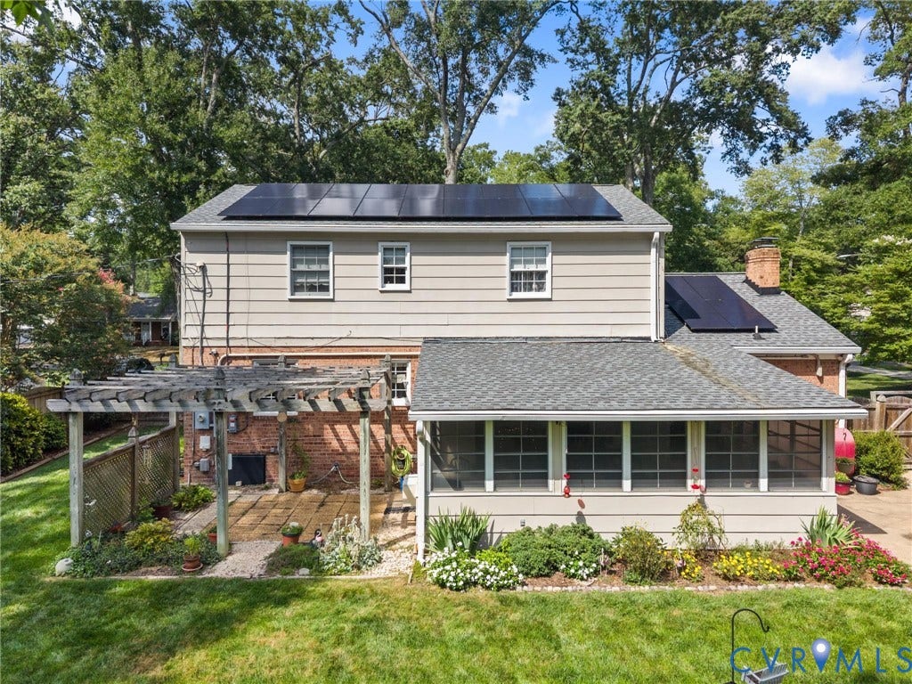 10205 Gwynnbrook Road, Richmond, VA 23235 Rear exterior with multiple solar panels, a screened porch, and a pergola-covered patio with brick paving