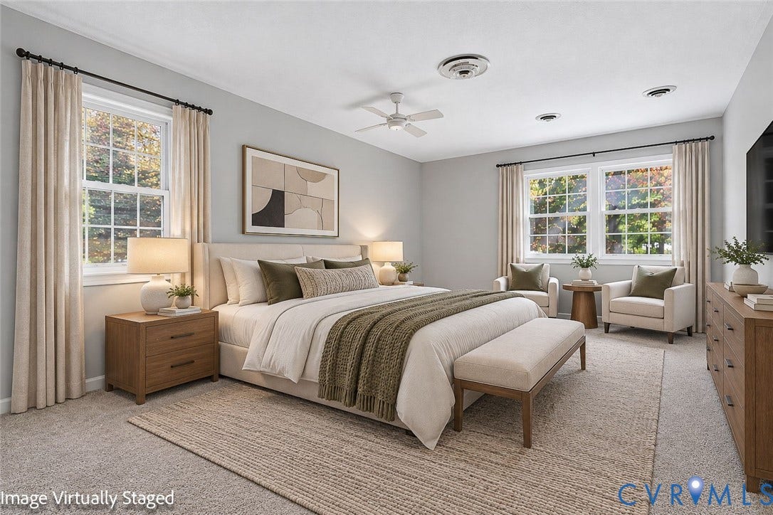 Spacious bedroom featuring neutral wall-to-wall carpeting, multiple windows with grid detailing, and a ceiling-mounted fan