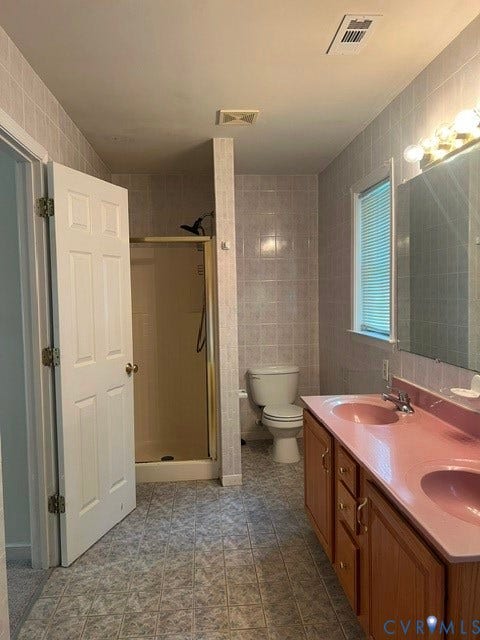 11419 Courthouse Acres Drive, Midlothian, VA 23114 Bathroom featuring tiled walls, a tiled shower enclosure, a toilet, and a double vanity with integrated sinks