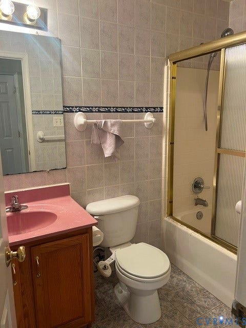 11419 Courthouse Acres Drive, Midlothian, VA 23114 Bathroom featuring tiled walls, a vanity with a pink countertop, a commode, and a shower with a gold-tone framed glass enclosure