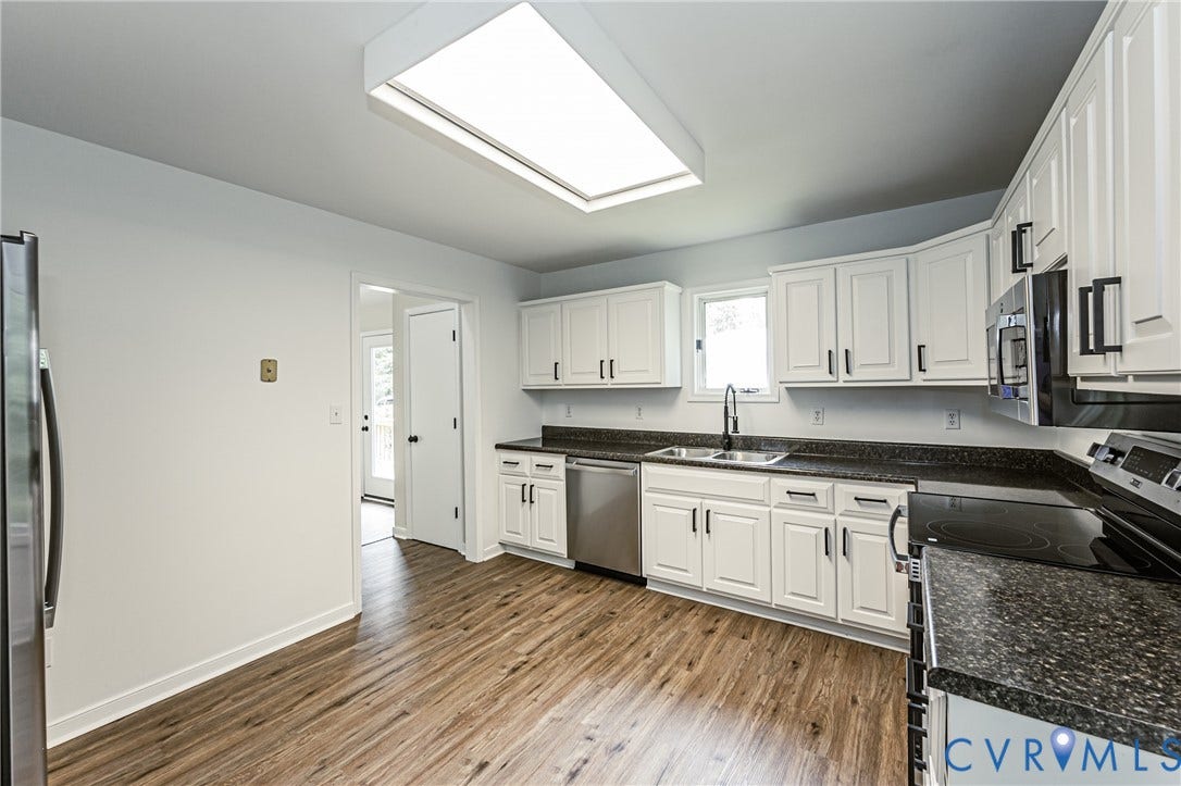 1520 Willow Brook Road, Louisa, VA 23024 Kitchen featuring LVP, white cabinetry with dark hardware, dark countertops, stainless steel appliances, and a rectangular ceiling light fixture