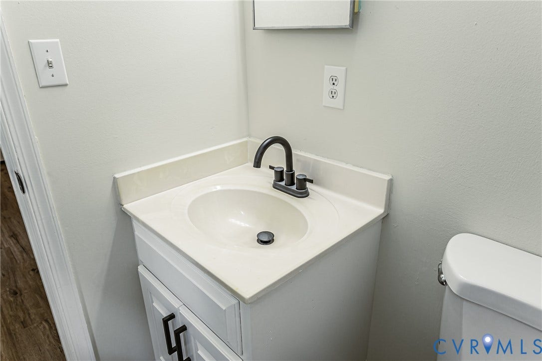 1520 Willow Brook Road, Louisa, VA 23024 White vanity with a single basin sink, matte black faucet, and coordinating hardware