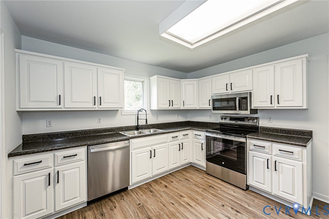 1520 Willow Brook Road, Louisa, VA 23024 White shaker-style cabinetry with black hardware, dark laminate countertops, and stainless steel appliances