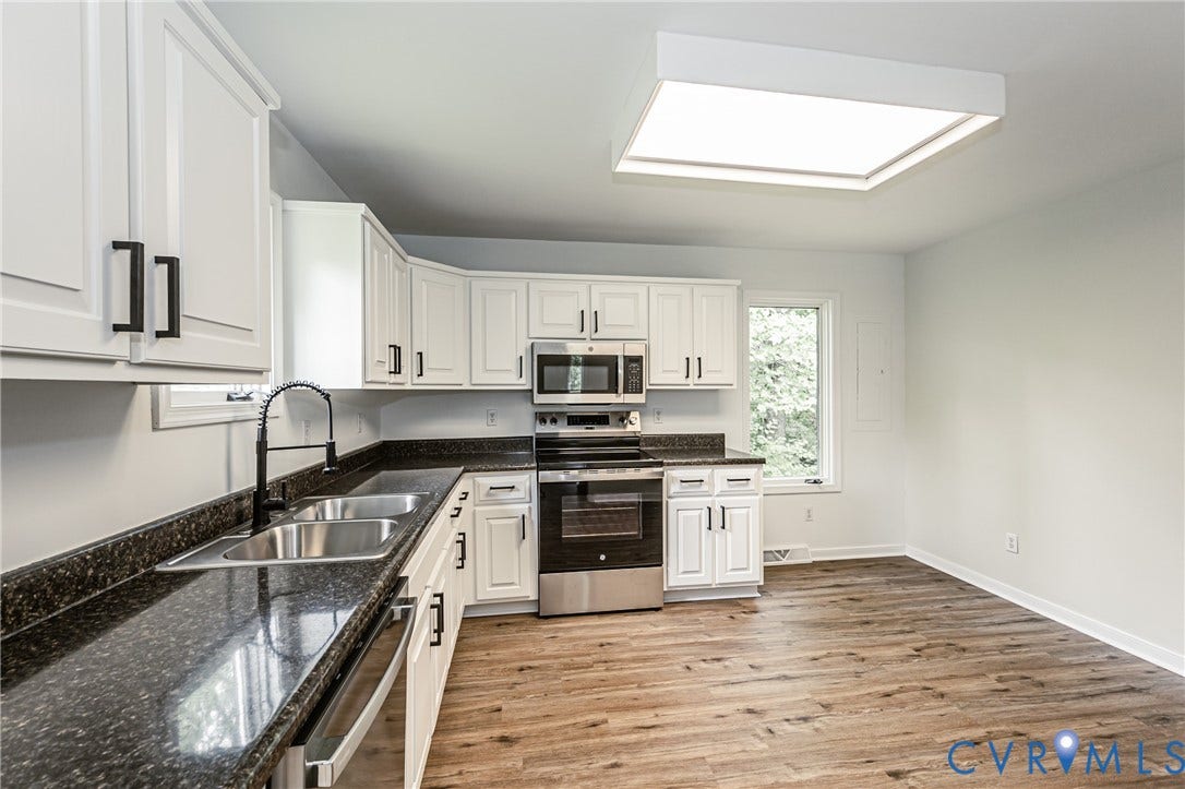 1520 Willow Brook Road, Louisa, VA 23024 White cabinetry, dark stone-finish countertops, wood-finish flooring, stainless steel appliances, and a square ceiling light fixture