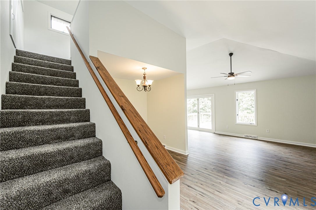 1520 Willow Brook Road, Louisa, VA 23024 Carpeted staircase with wood-finish handrails, vaulted ceiling, wood-finish flooring, and sliding glass doors