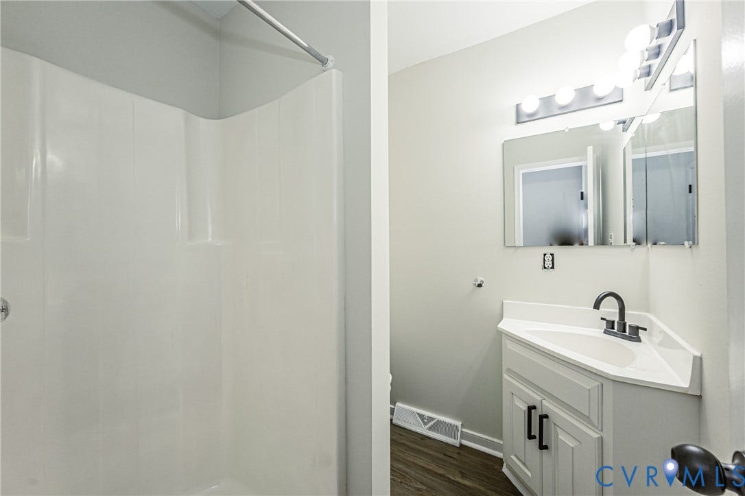 1520 Willow Brook Road, Louisa, VA 23024 Modern bathroom featuring a white vanity with ample storage, ceramic sink with matte black faucet, and mirrored with integrated lighting