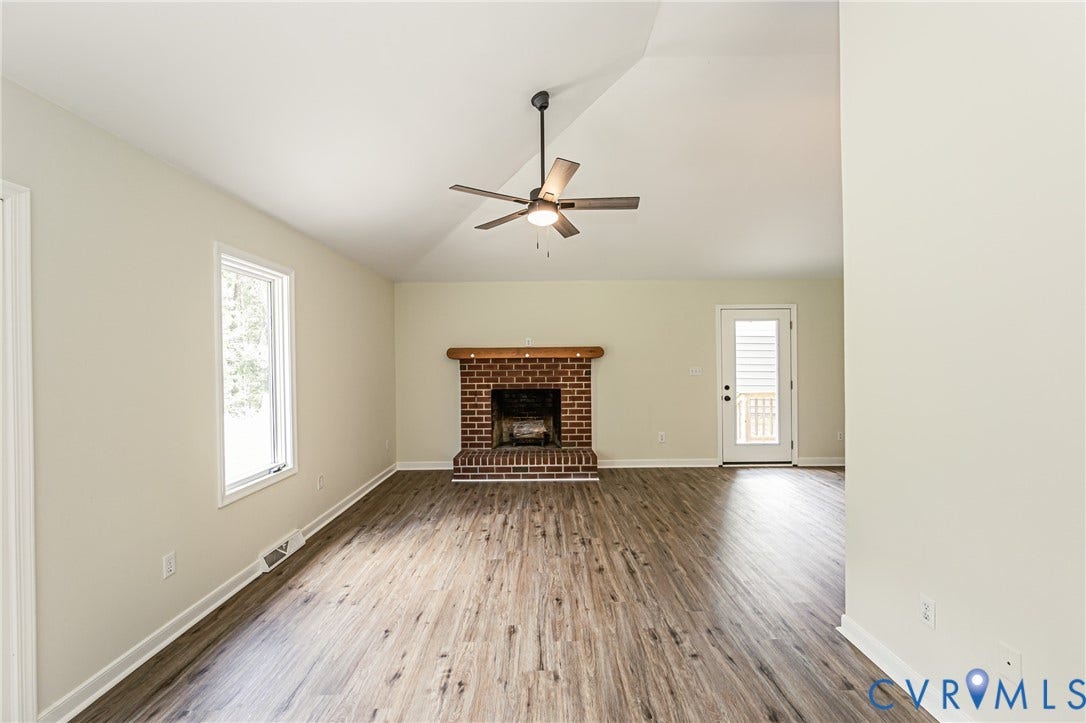 1520 Willow Brook Road, Louisa, VA 23024 Vaulted ceiling, LVP flooring, brick fireplace with wood mantel, ceiling fan, and white-framed window