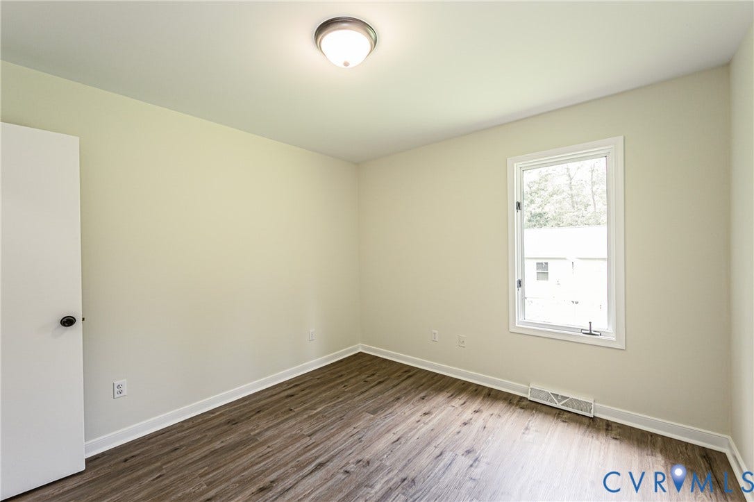 1520 Willow Brook Road, Louisa, VA 23024 LVP flooring, single window, white trim, flush mount ceiling light, and light-colored walls