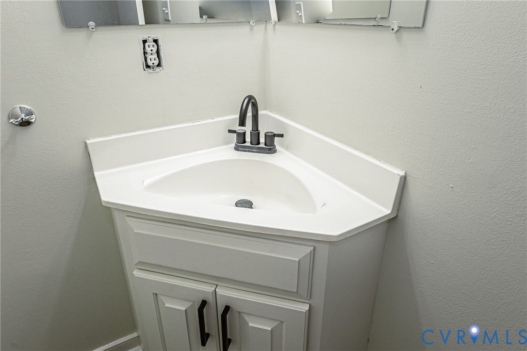1520 Willow Brook Road, Louisa, VA 23024 Corner vanity with a built-in sink, white countertop, and dark-finish faucet