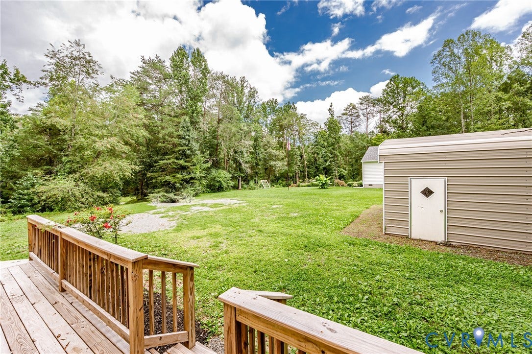 1520 Willow Brook Road, Louisa, VA 23024 Expansive green lawn with a wood deck, mature trees, and an auxiliary storage structure