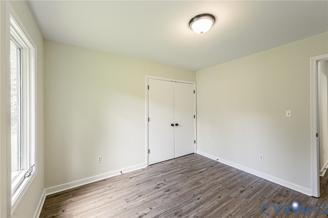 1520 Willow Brook Road, Louisa, VA 23024 LVP flooring, white trim, dual-sash window, and bi-fold closet doors