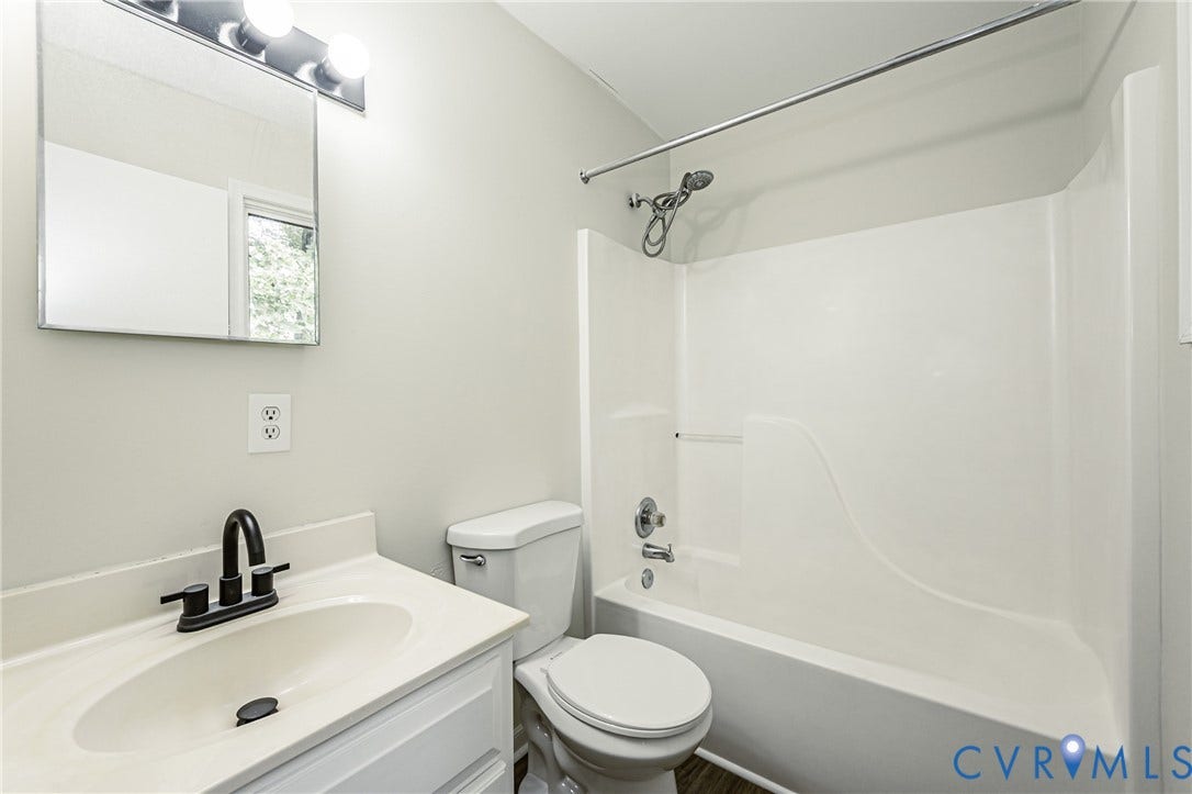 1520 Willow Brook Road, Louisa, VA 23024 Bathroom featuring a built-in tub with shower, white vanity with integrated sink, matte black faucet, and mirror