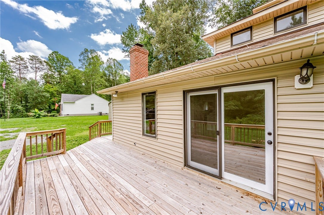 1520 Willow Brook Road, Louisa, VA 23024 Expansive wood deck with wood railings, siding exterior, brick chimney, and sliding glass door