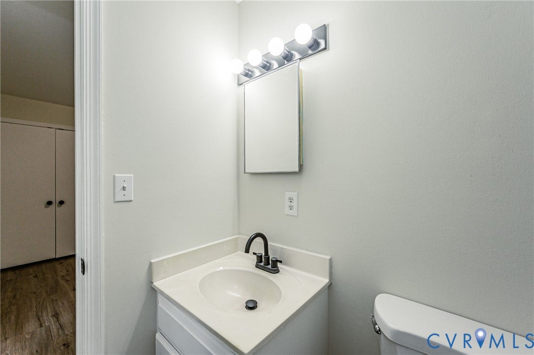 1520 Willow Brook Road, Louisa, VA 23024 Corner vanity with a built-in sink, dark finish faucet, and an overhead light fixture