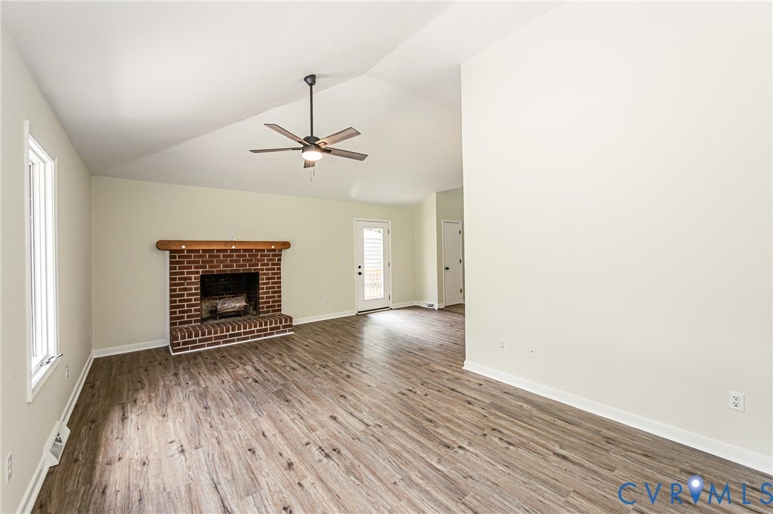 1520 Willow Brook Road, Louisa, VA 23024 Vaulted ceiling, brick fireplace with wood mantel, LVP flooring, ceiling fan, and white walls