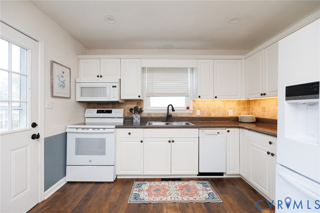 15525 Saddlebrook Road, Chesterfield, VA 23838 White cabinetry with matte black hardware, dark countertops, tile backsplash, wood-finish flooring, and a glass-paneled exterior door