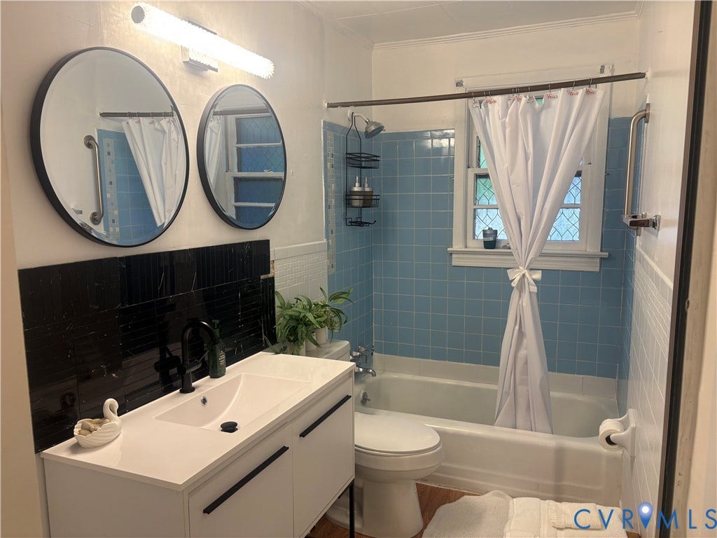 2443 Tignor Road, Richmond, VA 23224 Modern vanity with integrated sink, black accent faucet, and black marble-look tile backsplash