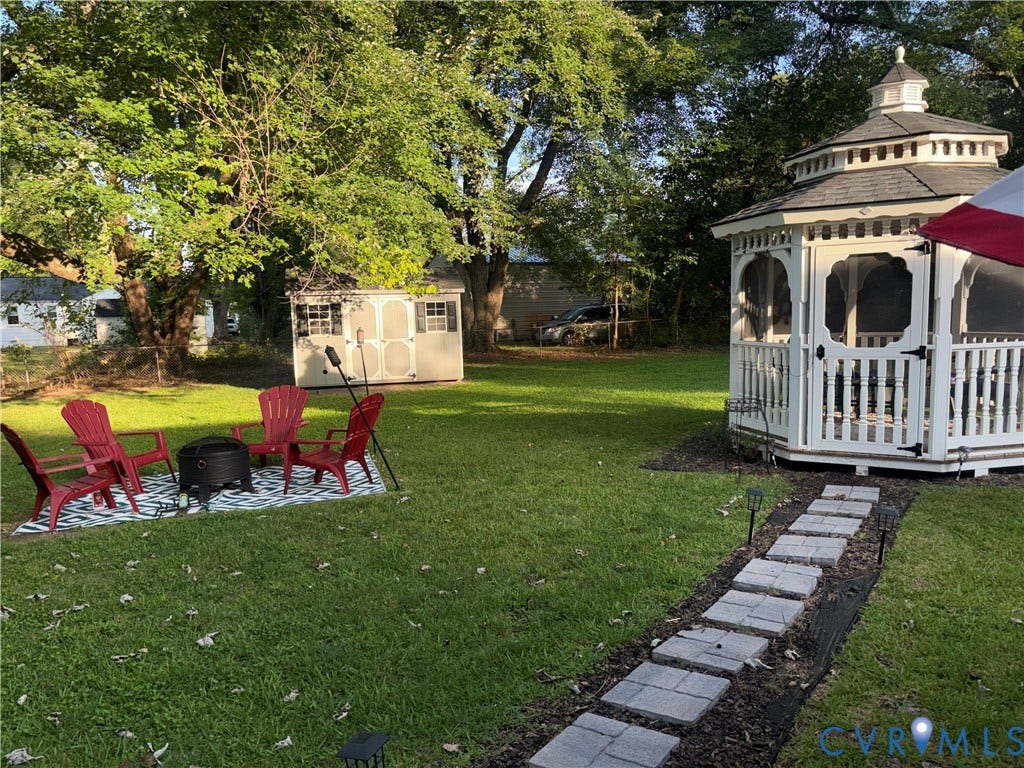 2443 Tignor Road, Richmond, VA 23224 Spacious yard featuring a white gazebo, a storage shed, and mature trees