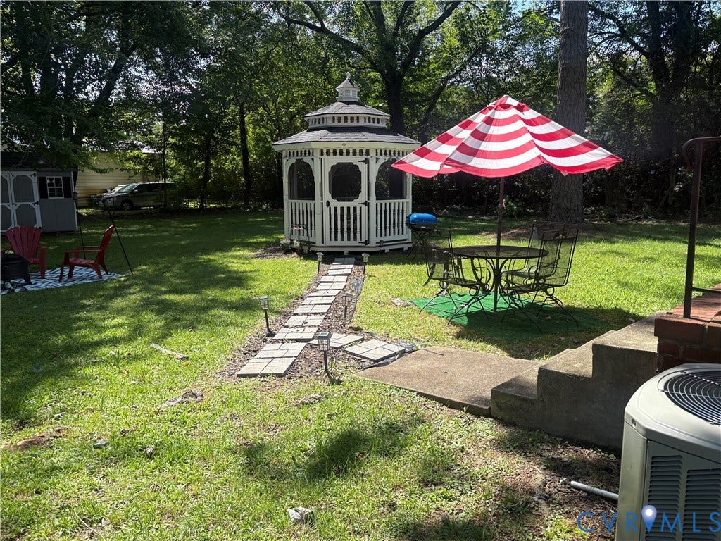 2443 Tignor Road, Richmond, VA 23224 Spacious backyard featuring a white gazebo, concrete steps, a stepping stone path, and a storage shed