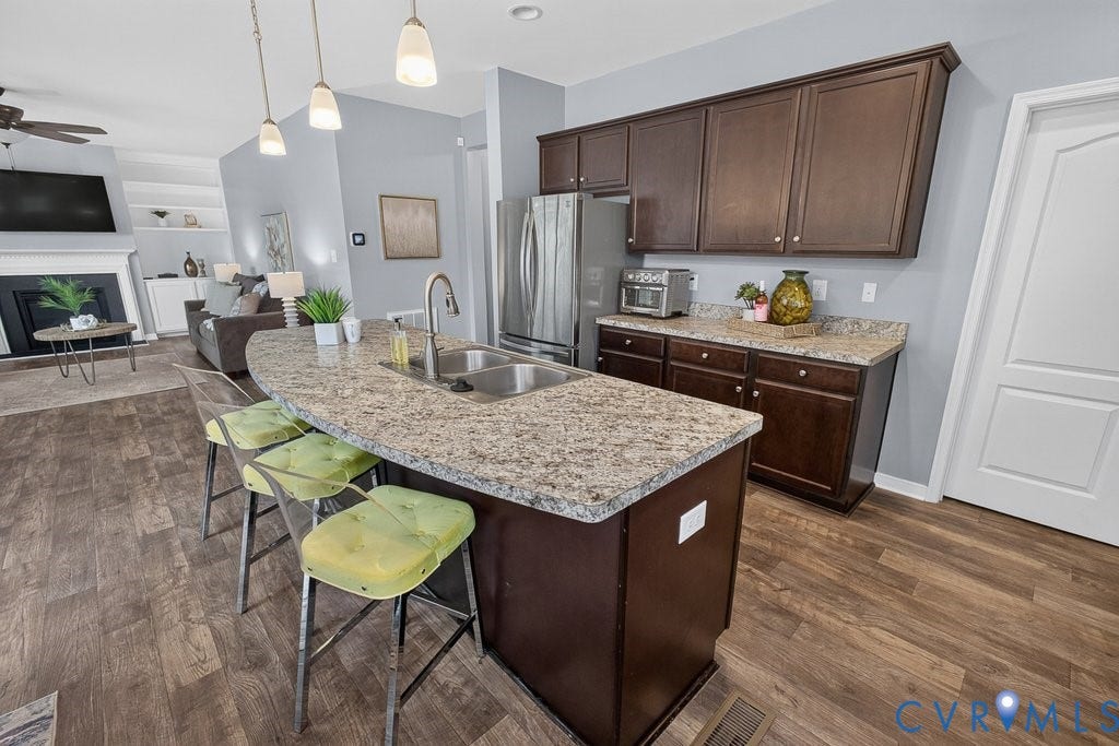 7401 Nicklaus Circle, Moseley, VA 23120 Kitchen island with a double basin stainless steel sink, a gooseneck faucet, and pendant lighting