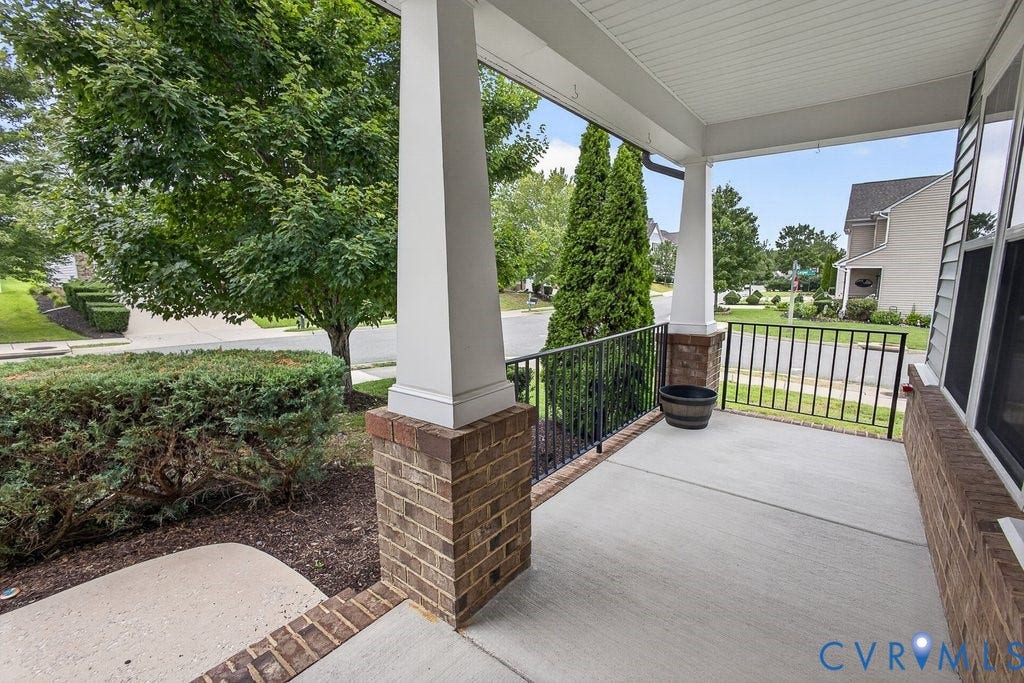 7401 Nicklaus Circle, Moseley, VA 23120 Covered front porch with concrete flooring, brick columns, and a black wrought iron railing