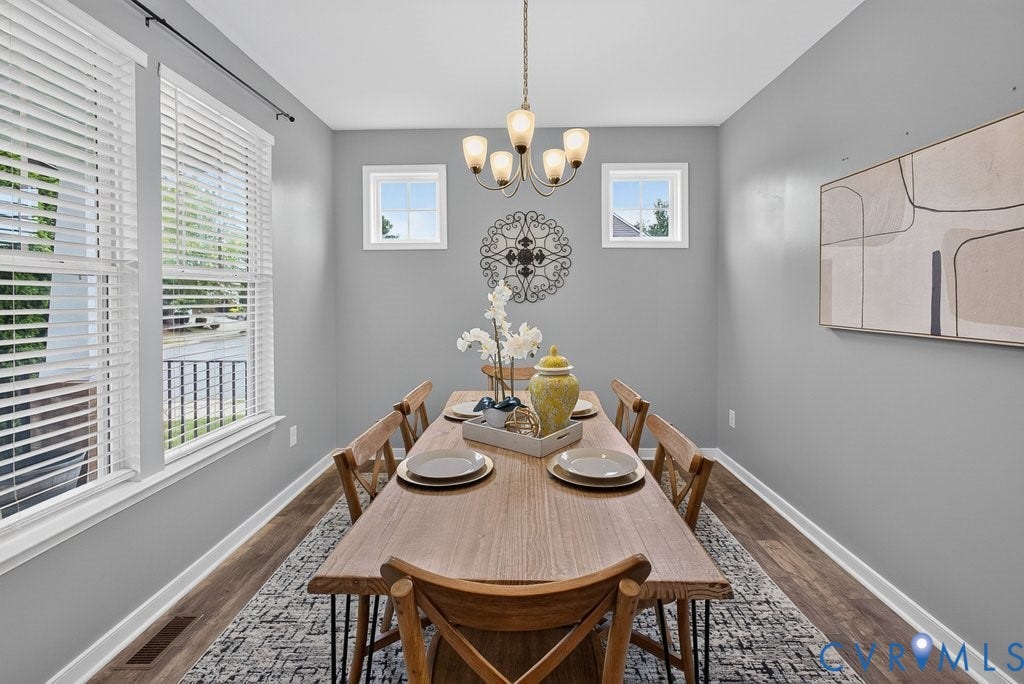 7401 Nicklaus Circle, Moseley, VA 23120 Recessed dining space featuring multiple windows, a multi-light chandelier, and wood-finish flooring
