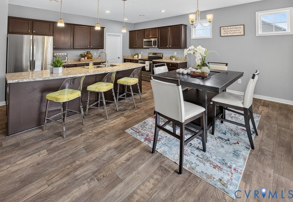 7401 Nicklaus Circle, Moseley, VA 23120 Kitchen featuring dark wood cabinetry, stainless steel appliances, light-toned granite countertops, and wood-finish flooring