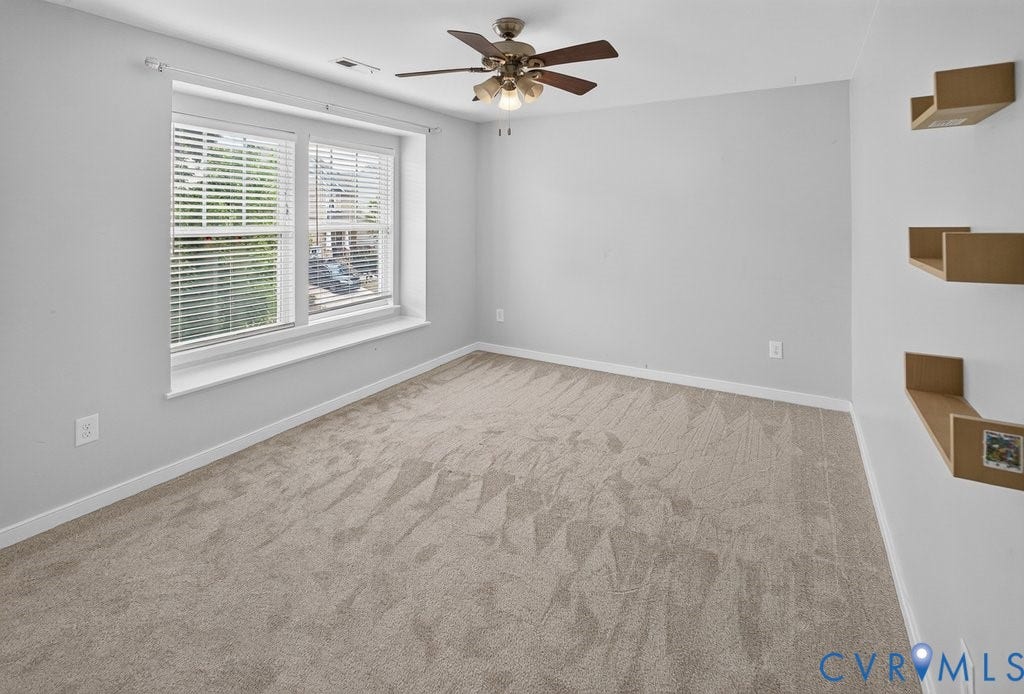 7401 Nicklaus Circle, Moseley, VA 23120 Bedroom 3 -Neutral-toned carpet flooring, a large window with blinds, a ceiling fan with integrated lighting, and built-in floating shelves