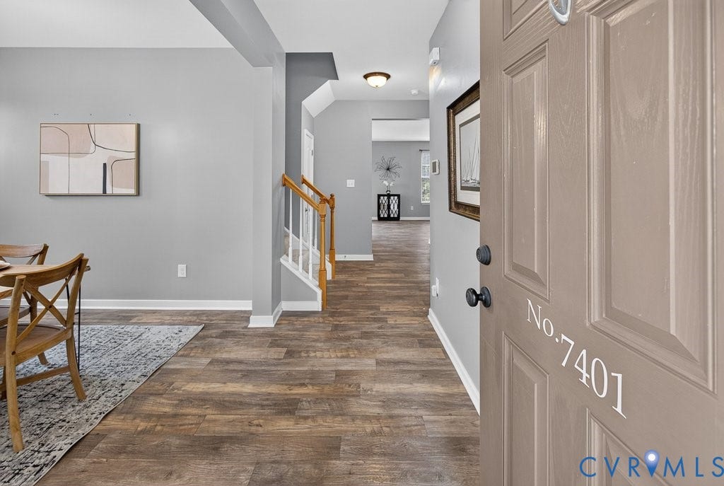 7401 Nicklaus Circle, Moseley, VA 23120 Entryway with wood-finish flooring, light gray wall paint, white trim, and a staircase featuring wood handrails and white balusters