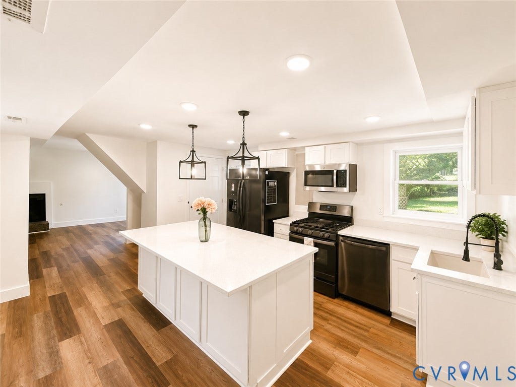 9018 Brucewood Drive, Midlothian, VA 23235 Open-concept kitchen with a central island, recessed lighting, wood-finish flooring, white cabinetry, and stainless steel appliances