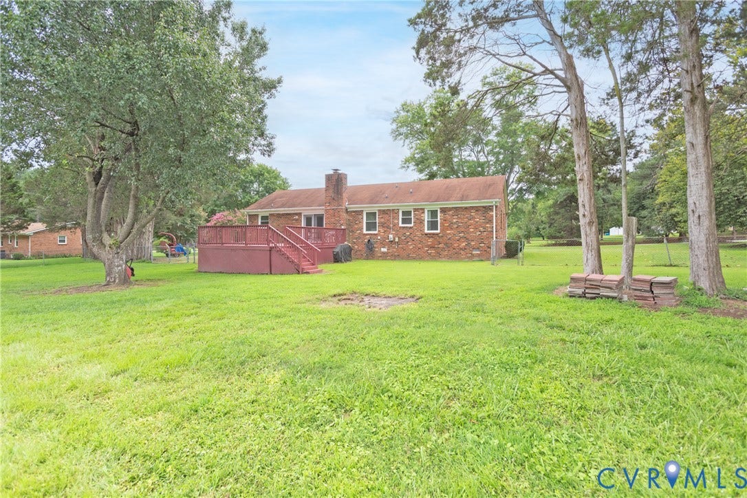 2730 Kinvan Road, Henrico, VA 23231 Expansive grassy yard with mature trees, a red brick exterior, and a built-in wooden deck with stairs