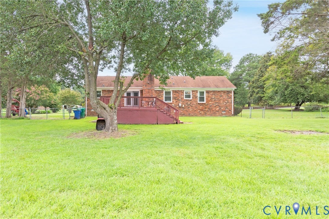 2730 Kinvan Road, Henrico, VA 23231 Expansive rear yard with mature trees, a red brick exterior, and a built-in wooden deck