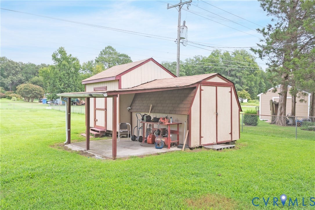 2730 Kinvan Road, Henrico, VA 23231 Two storage sheds with a covered concrete patio, featuring a single door entry and gable rooflines
