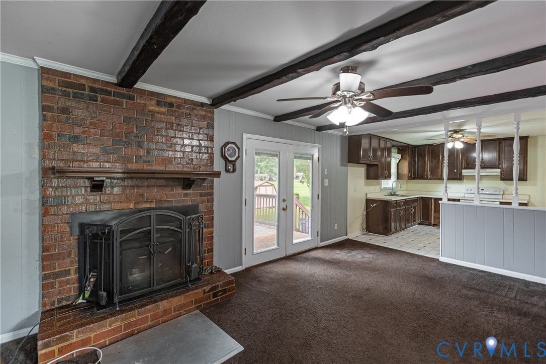 2730 Kinvan Road, Henrico, VA 23231 Living area featuring exposed ceiling beams, a brick fireplace with a wood mantel, and french doors