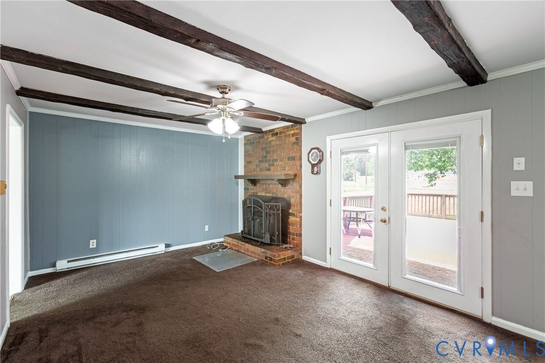 2730 Kinvan Road, Henrico, VA 23231 Exposed ceiling beams, brick fireplace with a metal insert, ceiling fan, and French doors leading to an exterior deck