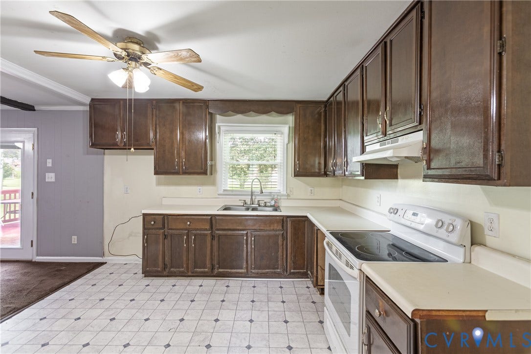 2730 Kinvan Road, Henrico, VA 23231 Kitchen featuring dark wood-finish cabinetry, light-toned countertops, a stainless steel sink, and a white electric range with an overhead hood