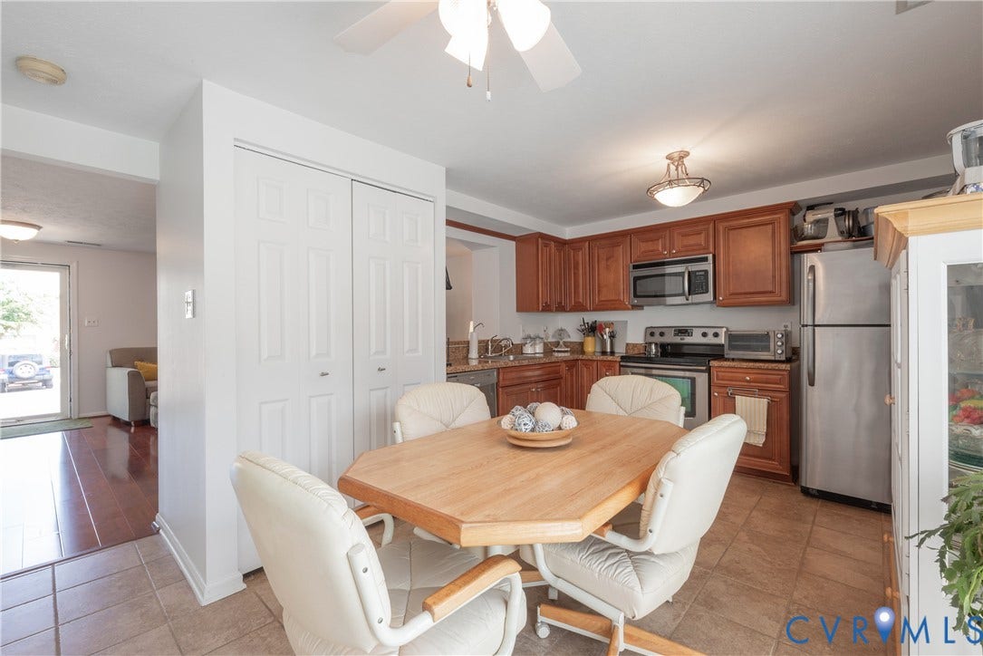 Kitchen featuring wood cabinetry, stainless steel appliances, and tile flooring