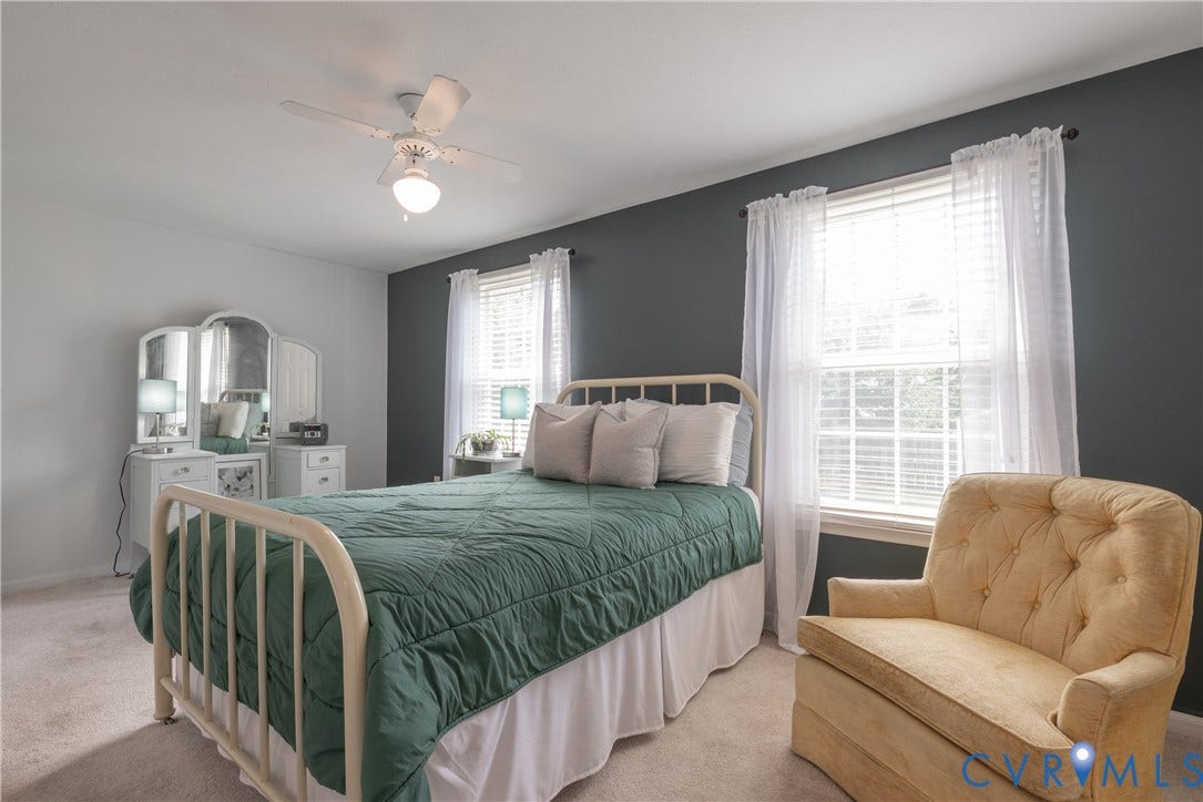 Recessed lighting, ceiling fan, carpeting, double windows with blinds, and a built-in vanity with mirrors