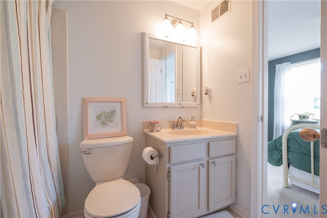 Bathroom featuring a single vanity with storage, a wall-mounted medicine cabinet, and an overhead light fixture