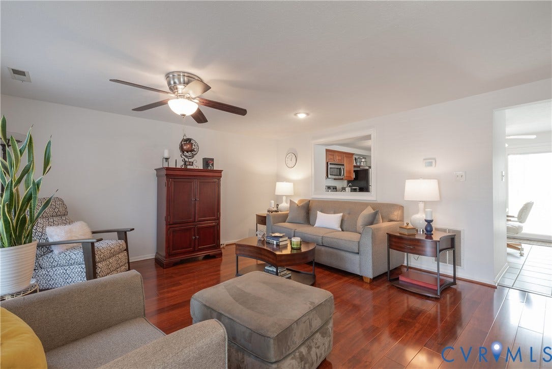 Polished wood-finish flooring, recessed lighting, ceiling fan, pass-through opening, and white wall finishes