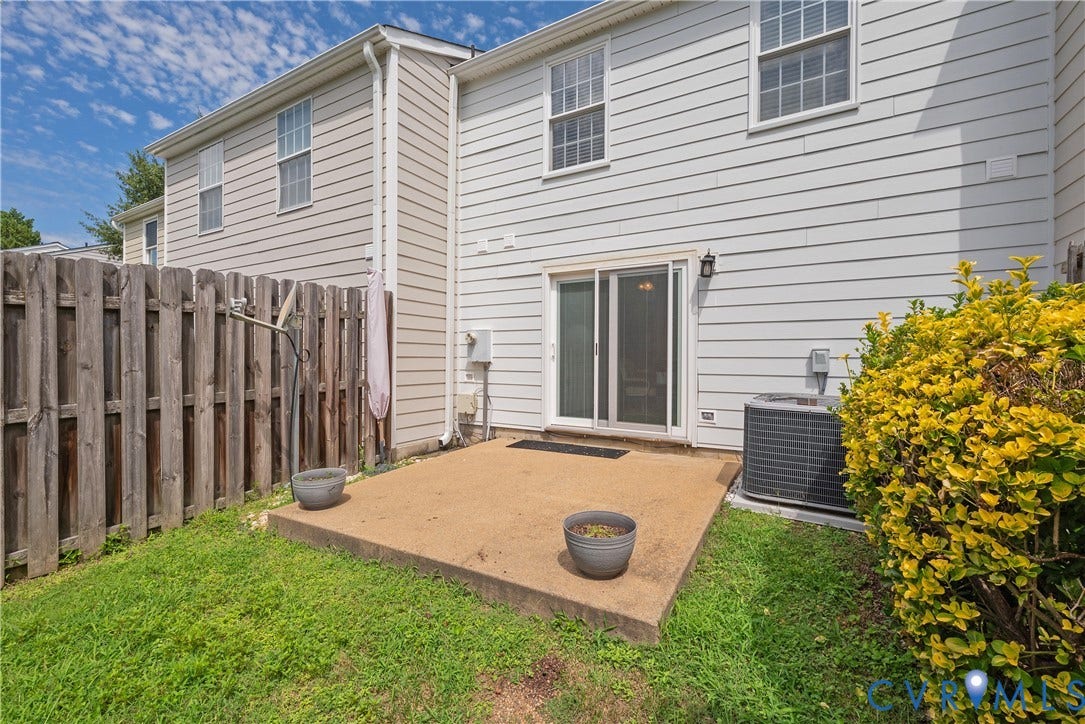 Concrete patio with sliding glass door access to the interior