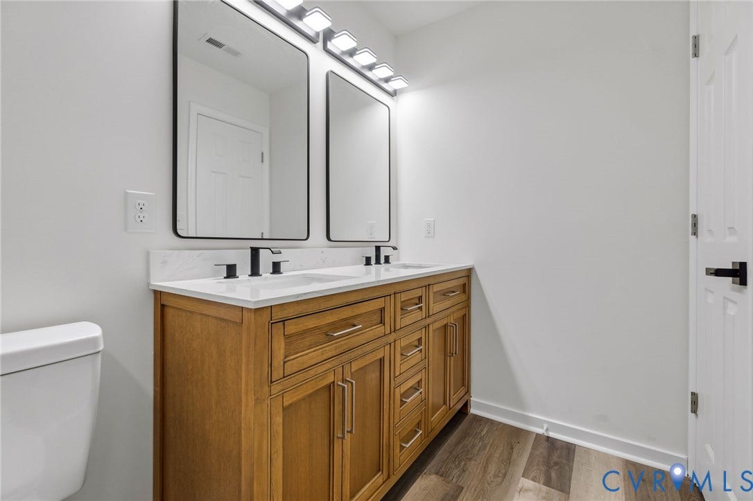 516 S South Street, Myers, Petersburg, VA 23803 Double vanity with wood-finish cabinetry, white countertop, and dual matte black faucets