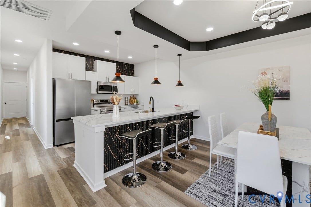 516 S South Street, Myers, Petersburg, VA 23803 Kitchen featuring a large island with a waterfall countertop, integrated stainless steel appliances, recessed lighting, wood-finish flooring, and a contemporary light fixture