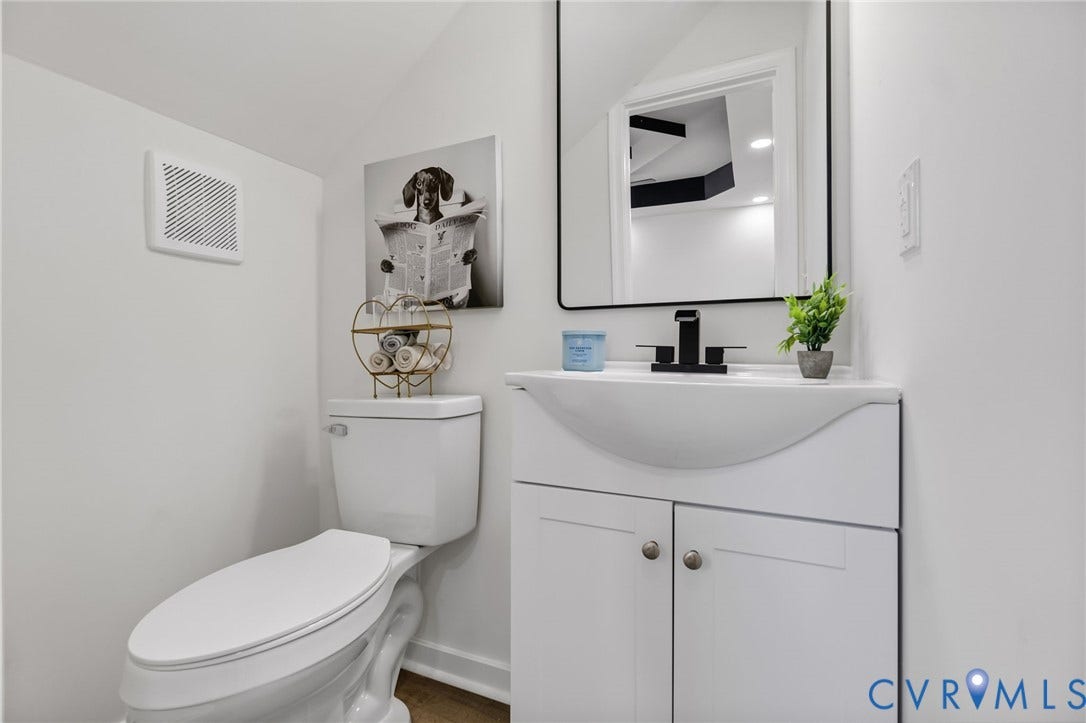 516 S South Street, Myers, Petersburg, VA 23803 White vanity with integrated sink, matte black faucet, and framed mirror