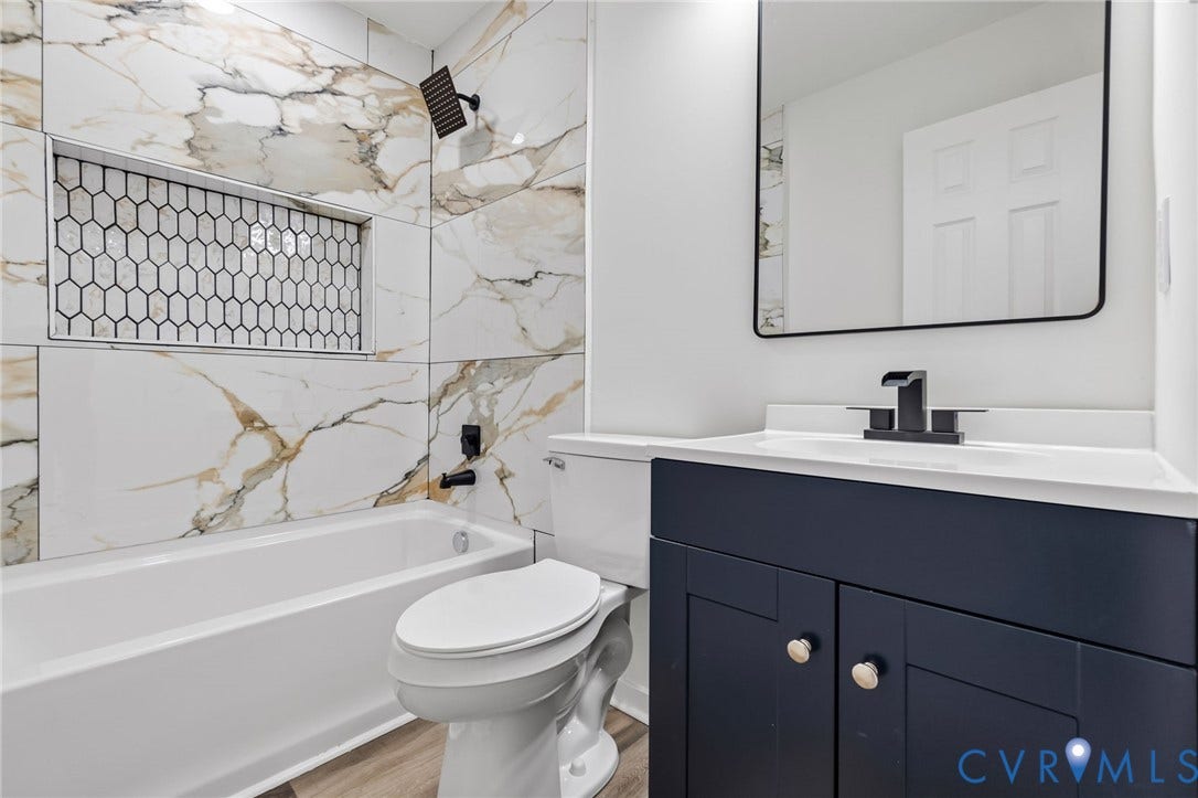 516 S South Street, Myers, Petersburg, VA 23803 Bathroom featuring a vanity with a dark blue cabinet, a white countertop, and a black faucet