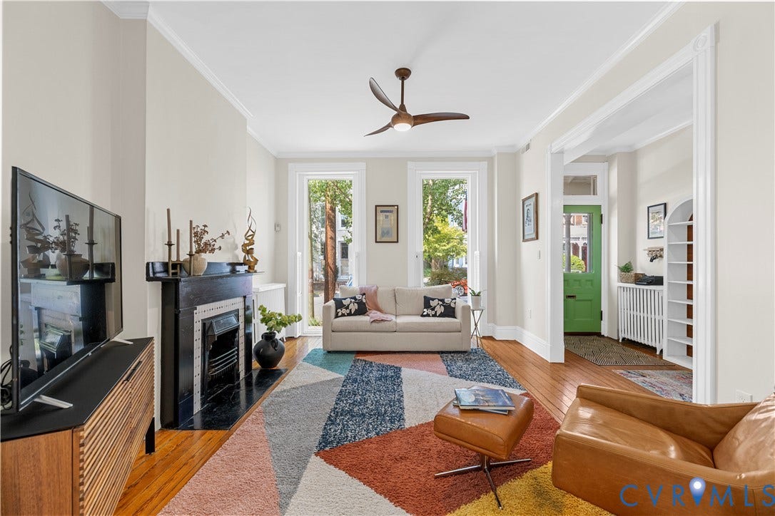 109 N Morris Street, The Fan, Richmond, VA 23220 Hardwood flooring throughout, a decorative fireplace with a dark mantel, white trim, and a ceiling fan