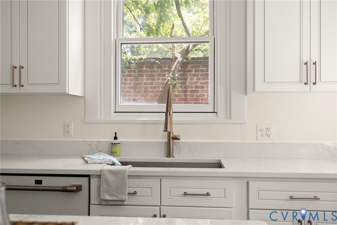 109 N Morris Street, The Fan, Richmond, VA 23220 White shaker-style cabinetry with bronze hardware, white stone countertops, undermount sink with a bronze gooseneck faucet, and integrated dishwasher