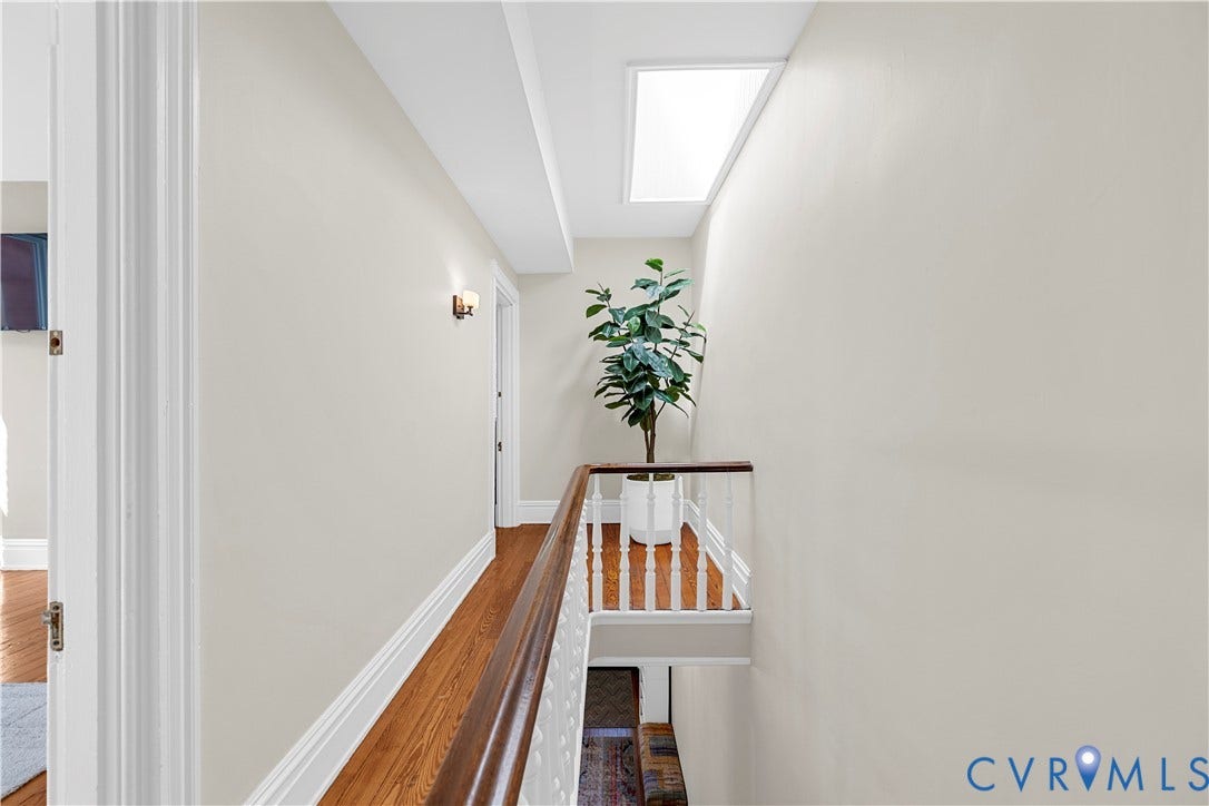 109 N Morris Street, The Fan, Richmond, VA 23220 Wood-finish flooring, white spindle railing, skylight, and wall-mounted lighting fixtures