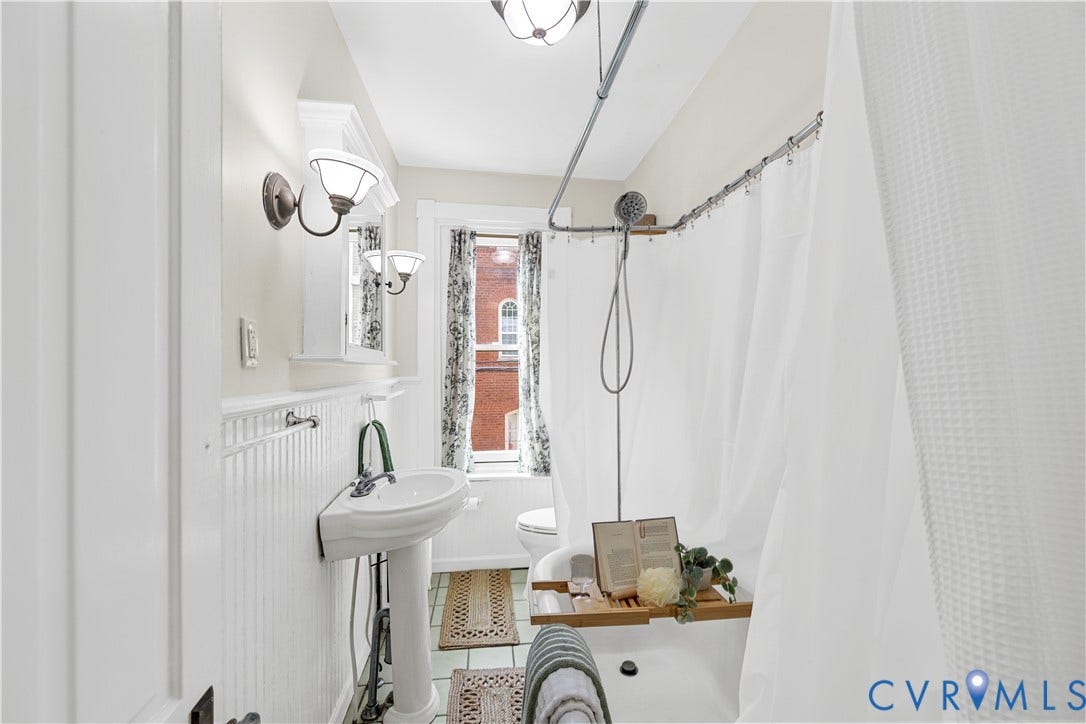 109 N Morris Street, The Fan, Richmond, VA 23220 Pedestal sink, wall-mounted sconce lighting, beadboard wainscoting, built-in medicine cabinet, and a shower/tub combination