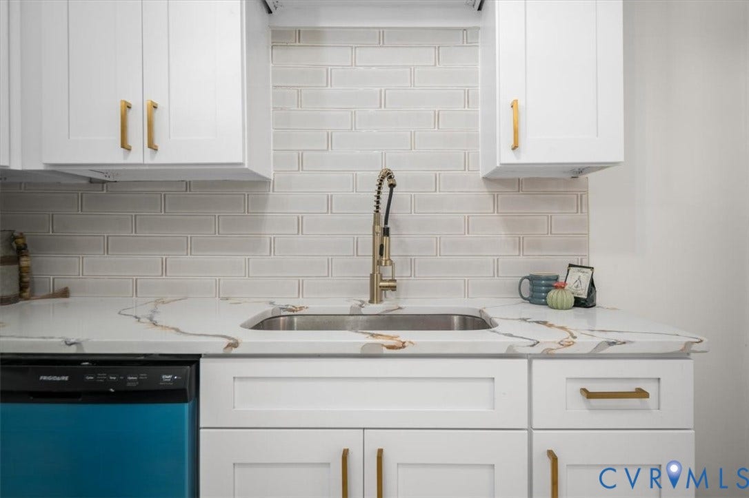3510 Hanover Avenue, Museum District, Richmond, VA 23221 White shaker cabinetry with gold-tone hardware, a stainless steel sink, a pull-down sprayer faucet, a dishwasher, and a light-toned subway tile backsplash